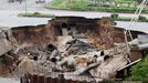 This picture taken on August 19, 2012 shows a sinkhole appearing in the middle of a key peripheral road, allegedly due to heavy rain in Hanoi. Typhoon Kai-Tak, which slammed into northern Vietnam over the weekend, has killed at least 17 people, damaged thousands of houses and flooded valuable crops, authorities said on August 20. AFP PHOTO