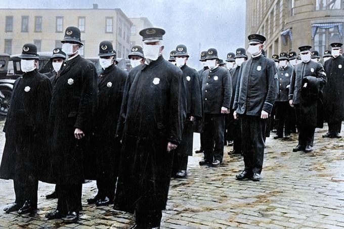 Policisté v Seattlu nosí roušky na ochranu před španělskou chřipkou, 1918.  Kolorovaný historický snímek.