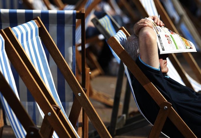 A man sunbathes in a deckchair during the hot weather in London August 18, 2012. REUTERS/Luke MacGregor (BRITAIN - Tags: ENVIRONMENT) Published: Srp. 18, 2012, 4:03 odp.