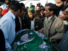 Účastníci shromáždění v Rávalpindí odnášejí tělo mrtvého muže. Přikryli jej plakátem bývalého pákistánského premiéra Naváze Šarífa.