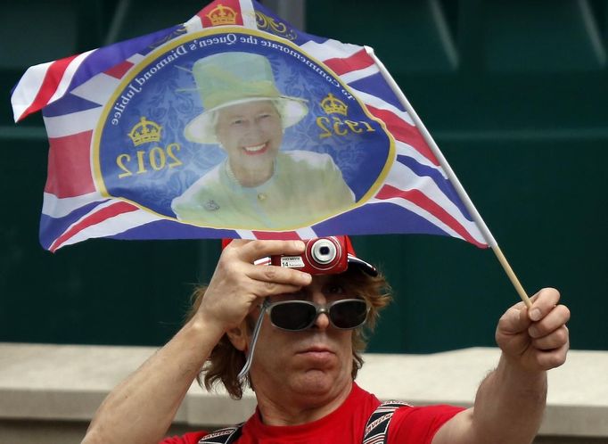 A man takes a picture of a Union flag as spectators line Parliament Square to see the Queen in London June 5, 2012. Four days of nationwide celebrations during which millions of people have turned out to mark the Queen's Diamond Jubilee conclude on Tuesday with a church service and carriage procession through central London. REUTERS/Kevin Coombs (BRITAIN - Tags: SOCIETY ROYALS) Published: Čer. 5, 2012, 1:35 odp.