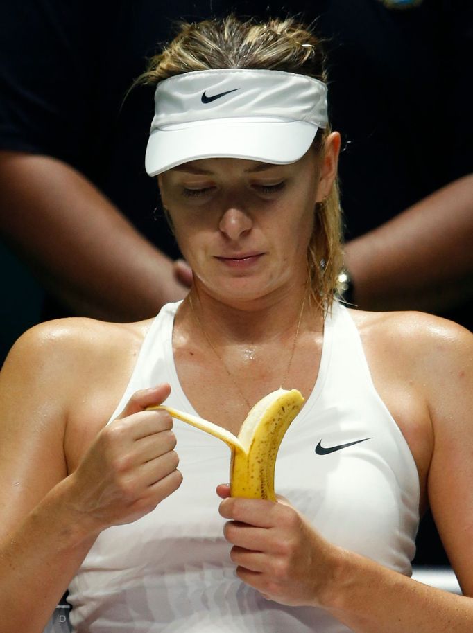 Maria Sharapova of Russia eats a banana as she rests between games against Petra Kvitova of the Czech Republic during their WTA Finals tennis match at the Singapore Indoo