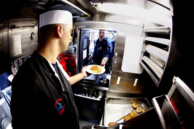 April 24, 2011 - Cape Canaveral, Florida, U.S. - -- Cape Canaveral, Fla. -- Tyler Keyes, left, Culinary Specialist Seaman, of Stillwater, Minnesota, serves lunch to Don Mikolajczak, Machinist's Mate Chief Senior, aboard the USS Annapolis (SSN 760), a S6G nuclear reactor powered fast attack submarine, sailing from Cape Canaveral on Sunday. The USS Annapolis measures 362 ft. in length and 33 ft. at the beam, a diving depth of over 400 ft., 27+ mph, 12 vertical launch missile tubes, 4 torpedo tubes, and a crew of 130 enlisted submariners. The submarine was commissioned April 11, 1992 with its homeport in Groton, Connecticut. USS Annapolis sailed to the 21st Anniversary of Fleet Week at Port Everglades, Fort Lauderdale. (Credit Image: © Gary Coronado/The Palm Beach Post) ( automatický překlad do češtiny )