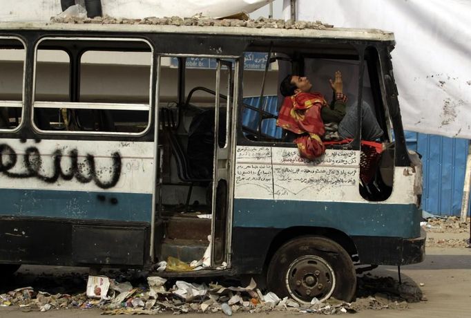 Modlitba ve zničeném autobuse poblíž káhirského náměstí Tahrír.