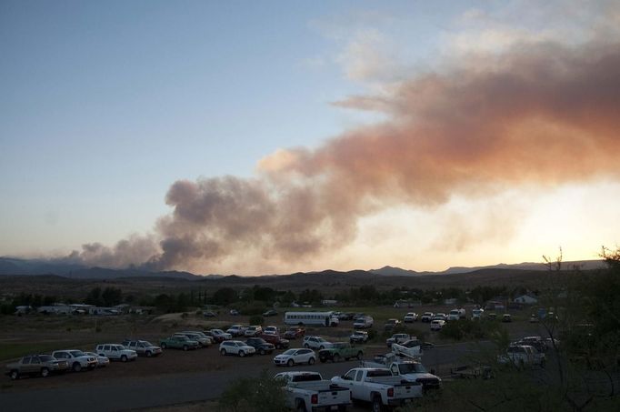 A view of the Gladiator Fire near Crown King, Arizona as shown from the fire operations base camp at Mayer High School in Mayer, Arizona May 15, 2012 in this photo obtained by Reuters May 20, 2012. Fires in Arizona, New Mexico and Colorado have forced the evacuation of several small towns and torched more than 65 square miles (168 square km) of forest, brush and grass in the U.S. Southwest. After getting a respite from winds on Saturday, firefighters on the Gladiator Fire faced a combination of dry vegetation and higher winds on Sunday and the days ahead. Picture taken May 15, 2012. REUTERS/Todd Tamcsin (UNITED STATES - Tags: DISASTER ENVIRONMENT) Published: Kvě. 21, 2012, 4:03 dop.