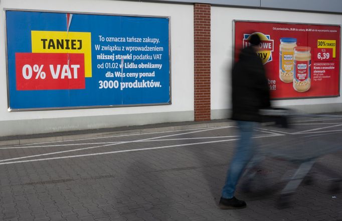 Muž v západopolském městě Slubice na hranicích s Německem míjí reklamní plakát, který zákazníky láká na nulové DPH u potravin.