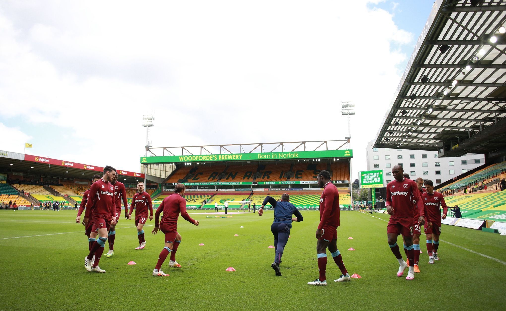 Hráči West Hamu se rozcvičují před zápasem na hřišti týmu Norwich City