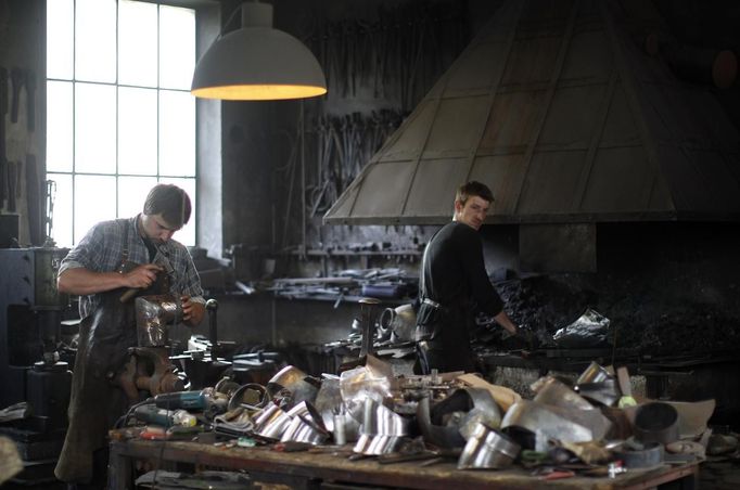 Blacksmith brothers Johann (R) and Georg Schmidberger work on harnesses for the Vatican Swiss Guard at their workshop in Molln, Upper Austria June 12, 2012. Johann, 29, and Georg, 28, produce made-to-order handmade harnesses for the Vatican, which take 120 hours of handiwork per piece and hardly differs from the 500-year-old originals. The brothers carry on the tradition of the blacksmith trade in the fifth generation of their family. REUTERS/Lisi Niesner (AUSTRIA - Tags: SOCIETY MILITARY) Published: Čer. 12, 2012, 10:19 odp.