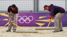 Simon Drew and Lenore Gerschwitz rake a practice beach volley ball court ahead of teams arriving for the London 2012 Olympic Games in London July 16, 2012. The London 2012 Olympic Games start in 11 days time. REUTERS/Luke MacGregor (BRITAIN - Tags: SPORT OLYMPICS VOLLEYBALL) Published: Čec. 16, 2012, 4:30 odp.