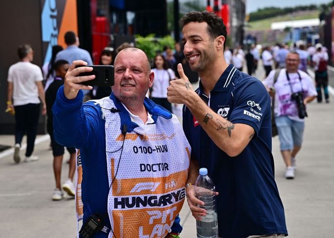 Daniel Ricciardo z Alpha Tauri a člen lékařského týmu během VC Maďarska F1 2023