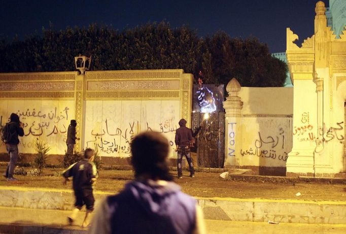 Protesters opposing Egyptian President Mohamed Mursi and the Muslim Brotherhood try to set a wall near one of the gates of the Presidential Palace on fire, as they chant anti-government slogans, in Cairo February 11, 2013. Protesters demanding the departure of Mursi clashed with police outside his palace on Monday on the second anniversary of the overthrow of veteran autocrat Hosni Mubarak. Dozens of youths threw rocks at the Ettihadiya palace after a peaceful march by thousands of demonstrators who accused Mursi's conservative Muslim Brotherhood of hijacking Egypt's democratic revolution and seeking to monopolise power. REUTERS/Asmaa Waguih (EGYPT - Tags: POLITICS CIVIL UNREST) Published: Úno. 11, 2013, 7:31 odp.