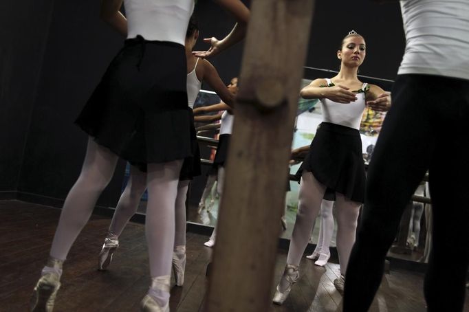 Girls perform during their ballet class at the 'Ballet Santa Teresa' academy in Rio de Janeiro August 13, 2012. 'Ballet Santa Teresa', a non-governmental organization (NGO) gives children who live in areas with social risk, some suffering domestic violence, free ballet classes and other activities as a part of socio-cultural integration project. Picture taken August 13, 2012. REUTERS/Pilar Olivares (BRAZIL - Tags: SOCIETY) Published: Srp. 16, 2012, 7:27 odp.