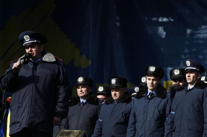 Police officers from Lviv who have arrived to join anti-government protesters appear on a stage in Independence Square in Kiev February 21, 2014.