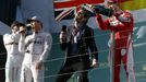 Australian former F1 driver Mark Webber (2nd R) has champagne poured on him by tSebastian Vettel (R) as he interviews Nico Rosberg (2nd L) in Melbourne.