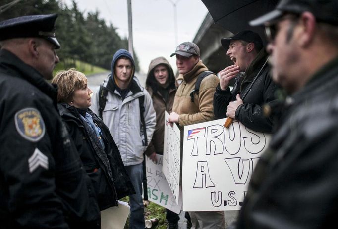 Seattle Police Department Officers talk with a group of gun buyers outside a gun buyback event in Seattle, Washington January 26, 2013. Participants received up to a $100 gift card in exchange for working handguns, shotguns and rifles, and up to a $200 gift card for assault weapons. The event lasted from 9 a.m. until shortly after noon, after the event ran out of $80,000 worth of gift cards. REUTERS/Nick Adams (UNITED STATES - Tags: POLITICS CIVIL UNREST) Published: Led. 27, 2013, 12:47 dop.