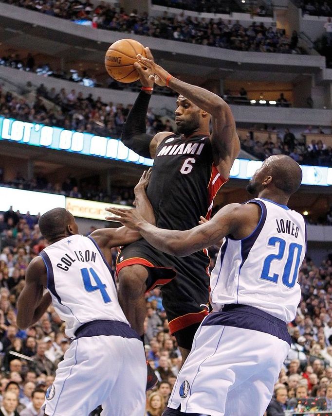 LeBron James z Miami střílí koš přes dvojici basketbalistů Dallasu Jonese a Collisona v zámořské NBA.