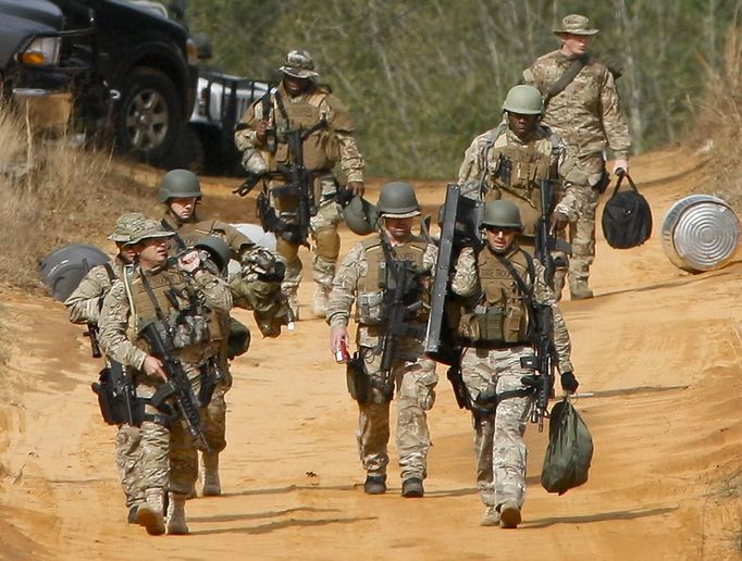 Law enforcement personnel walk away from the perimeter of the scene of a shooting and hostage taking in Midland City, Alabama, January 30, 2013. A gunman boarded an Alabama school bus ferrying children home from school on Tuesday and fatally shot the driver before fleeing with a young child and holing up in an underground bunker, Alabama media reported. Sheriff's officials confirmed that one person had been killed in a shooting involving a school bus in Alabama's Dale County but gave scant details other than to say that a child was present at the scene in Midland City. REUTERS/Phil Sears (UNITED STATES - Tags: CRIME LAW) Published: Led. 30, 2013, 10:50 odp.