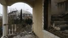 The Olympic stadium for the Sochi 2014 Winter Olympics is seen from a house that has to be torn down as it is within the perimeters of the Olympic Park in Adler, near Sochi February 18, 2013. Although many complexes and venues in the Black Sea resort of Sochi mostly resemble building sites that are still under construction, there is nothing to suggest any concern over readiness. Construction will be completed by August 2013 according to organizers. The Sochi 2014 Winter Olympics opens on February 7, 2014. REUTERS/Kai Pfaffenbach (RUSSIA - Tags: BUSINESS CONSTRUCTION ENVIRONMENT SPORT OLYMPICS) Published: Úno. 18, 2013, 5:42 odp.