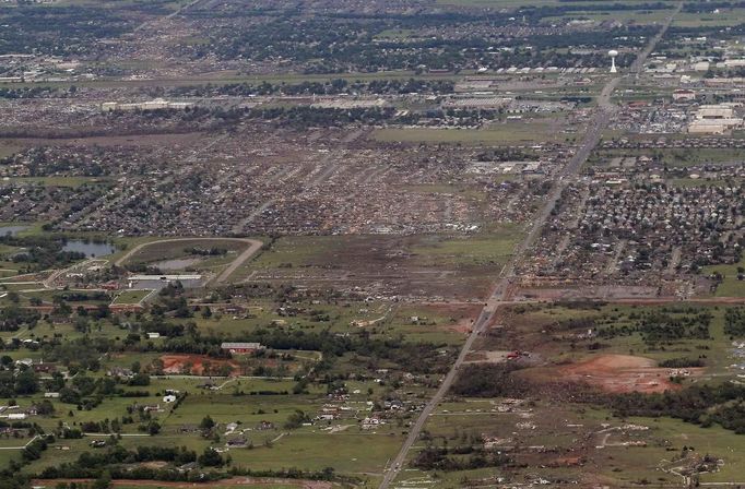 An aerial view of damage to neighborhoods in Moore, Oklahoma May 21, 2013, shows the path of destruction in the aftermath of a tornado which ravaged the suburb of Oklahoma City. Rescuers went building to building in search of victims and survivors picked through the rubble of their shattered homes on Tuesday, a day after a massive tornado tore through the Oklahoma City suburb of Moore, wiping out blocks of houses and killing at least 24 people. REUTERS/Rick Wilking (UNITED STATES - Tags: DISASTER ENVIRONMENT CITYSCAPE) Published: Kvě. 22, 2013, 3:04 dop.