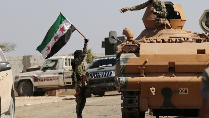 Voják s vlajkou syrských rebelů podporovaných Tureckem.