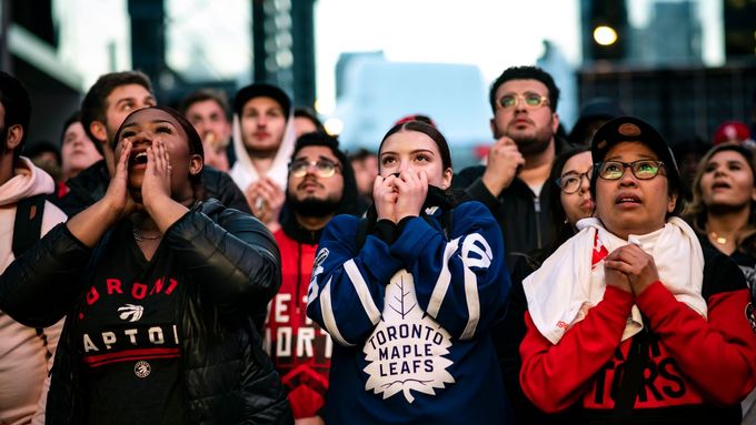 Lidé včetně fanynky hokejových Maple Leafs podporují Raptors ve finále basketbalové NBA.