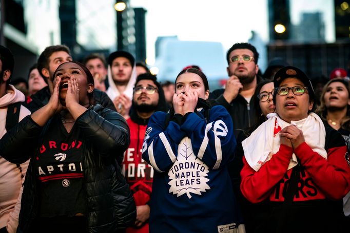 Lidé včetně fanynky hokejových Maple Leafs podporují Raptors ve finále basketbalové NBA.