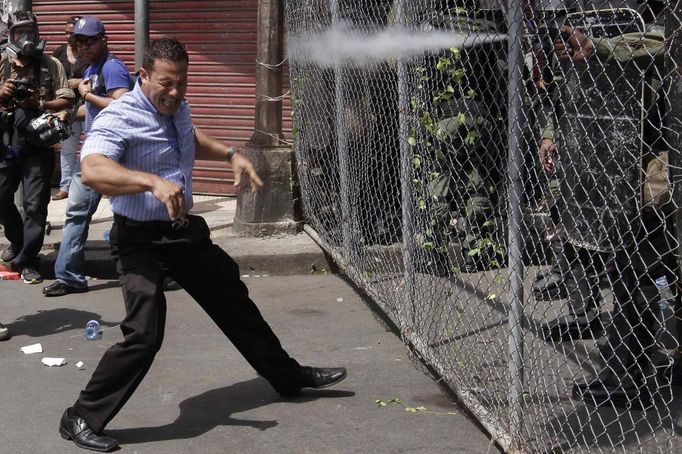 RNPS IMAGES OF THE YEAR 2012 - A protester reacts as riot policemen spray pepper gas during clashes outside the National Legislative Assembly in Panama City June 19, 2012. Students and labor unions from different organizations on Tuesday protested against a new law which allows the government to sell shares in government services, such as telecommunications and electricity. REUTERS/Carlos Jasso (PANAMA - Tags: BUSINESS CIVIL UNREST POLITICS EDUCATION TPX IMAGES OF THE DAY) Published: Pro. 4, 2012, 1 dop.