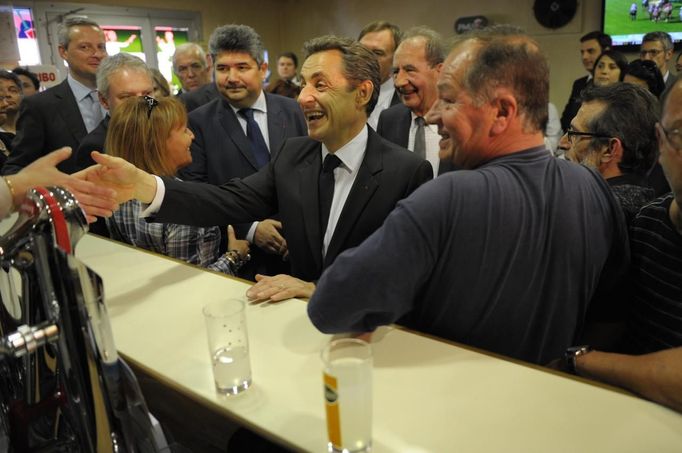 France's President and UMP party candidate for the 2012 French presidential elections Nicolas Sarkozy speaks with people in the L'Avenir cafe