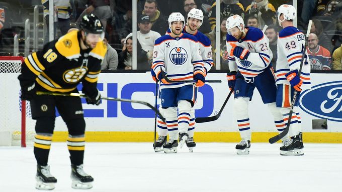 Český útočník Bostonu Pavel Zacha vydýchává zklamání, zatímco hokejistů Edmontonu se za ním radují z dalšího gólu