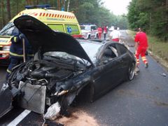 U zdemolovaného BMW zasahují hasiči a zdravotníci.