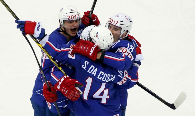 Stephane Da Costa of France (C) celebrates with team mates Antoine Roussel (L) and Yohann Auvitu (R) his second goal against Canada during the third period of their men's