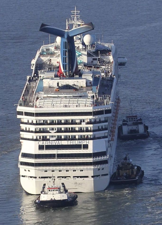 The Carnival Triumph cruise ship is towed towards the port of Mobile, Alabama, February 14, 2013. The 893-foot (272 meter) vessel, notorious for reports of raw sewage from overflowing toilets, has been without propulsion and running on emergency generator power since Sunday, when an engine room fire left it adrift in the Gulf of Mexico. REUTERS/ Lyle Ratliff (UNITED STATES - Tags: SOCIETY HEALTH TRAVEL MARITIME TRANSPORT BUSINESS) Published: Úno. 15, 2013, 12:18 dop.