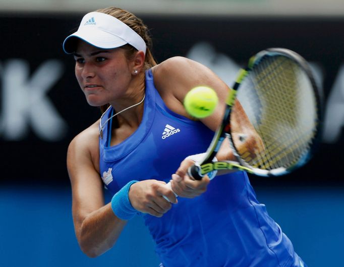 Monica Puig of Puerto Rico hits a return to Flavia Pennetta of Italy during their women's singles match at the Australian Open 2014 tennis tournament in Melbourne January