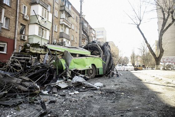 the whole demolished trolleybus from the temporary roadblock in front of the house.  Shot of war damage in Kiev, which is being intensively bombed by the Russian invading army.  15. 3. 2022