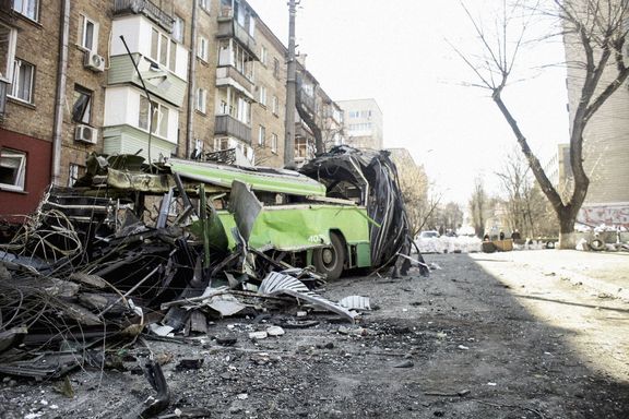 cela zdemolovaný trolejbus z provizorního zátarasu před domem. Záběr na válečné škody v Kyjevě, který je intenzivně bombardován ruskou invazní armádou. 15. 3. 2022