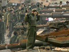 Izraelský voják se protahuje na tanku krátce poté, co se vrátil se svou jednotkou na sever Izraele.