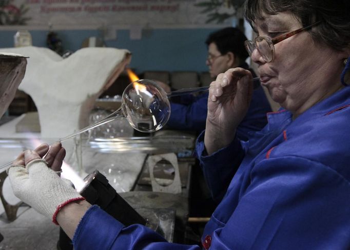 An employee works on a glass sphere for Christmas and New Year decorations, at the "Biryusinka" toys factory in Russia's Siberian city of Krasnoyarsk November 27, 2012. The factory, founded in 1942, produces decorative glass spheres, which can be found on Christmas trees all over the country and in Moscow's Kremlin in particular, during the festive season. REUTERS/Ilya Naymushin (RUSSIA - Tags: SOCIETY) Published: Lis. 27, 2012, 3:51 odp.