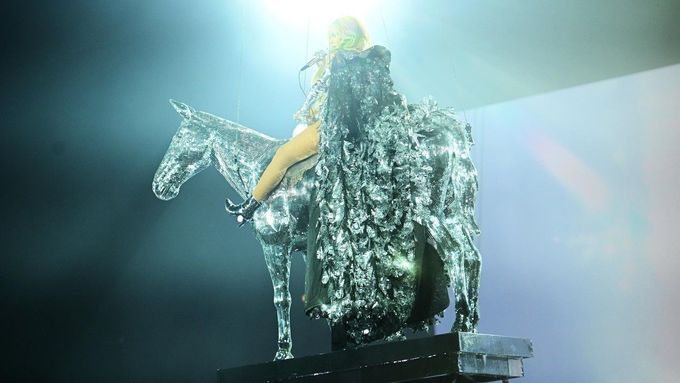 Beyoncé vylézá z lastury a létá na koni. Za jejím turné lidé jezdí z celého světa