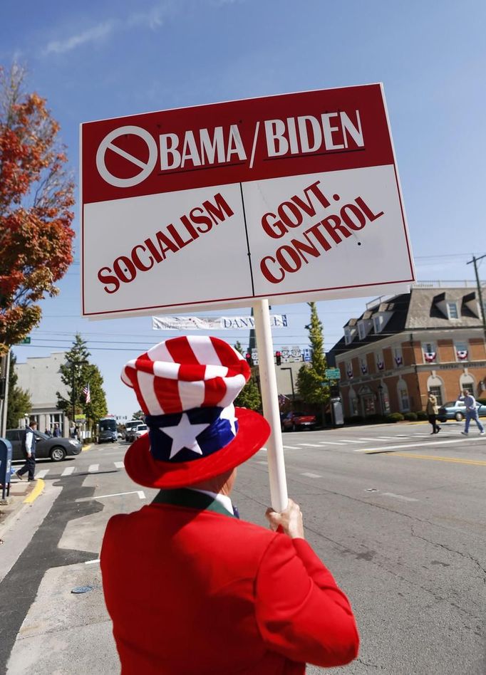 A supporter of Republican challengers Mitt Romney and Paul Ryan holds up a sign on the main street of Danville, Kentucky October 11, 2012. The streets of this small town were abuzz ahead of the vice presidential debate between U.S. Vice President Joe Biden and Republican vice presidential nominee Ryan, at Centre College in Danville Thursday night. REUTERS/Kevin Lamarque (UNITED STATES - Tags: POLITICS ELECTIONS) Published: Říj. 11, 2012, 8:59 odp.