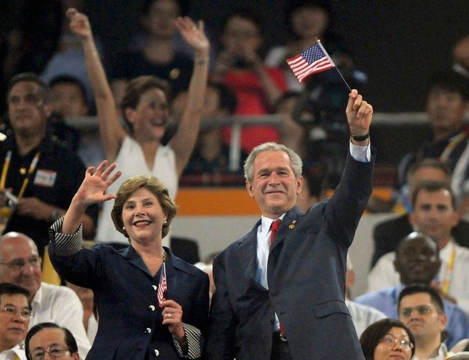 Prezident G.W.Bush s manželkou Laurou mávají z tribuny americkým sportovcům pochodujícím po ploše Národního stadionu.