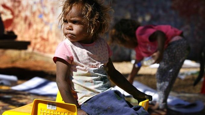 Dítě sedí vedle komunitního centra v "Hidden Valley" nedaleko australského města Alice Springs.
