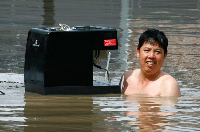 Majitel obchodu z předměstí Brisbane zachraňuje kávovar.