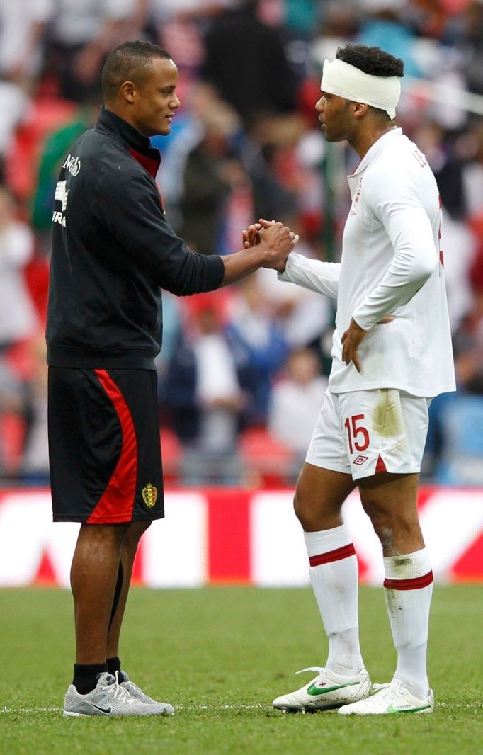 Soupeři v národních týmech, ale spoluhráči z Manchesteru City Vincent Kompany a Joleon Lescott se zdraví po přátelském fotbalovém utkání Anglie - Belgie.