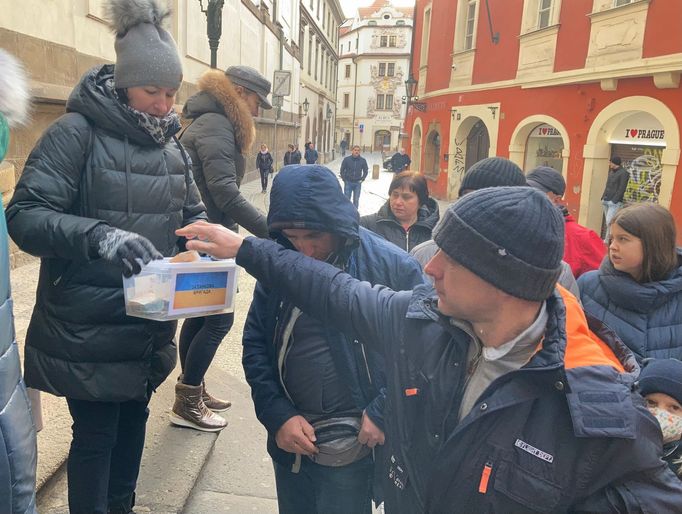 Ukrajinci před příchodem do pražského kostela přispívají na pomoc ukrajinské armádě.