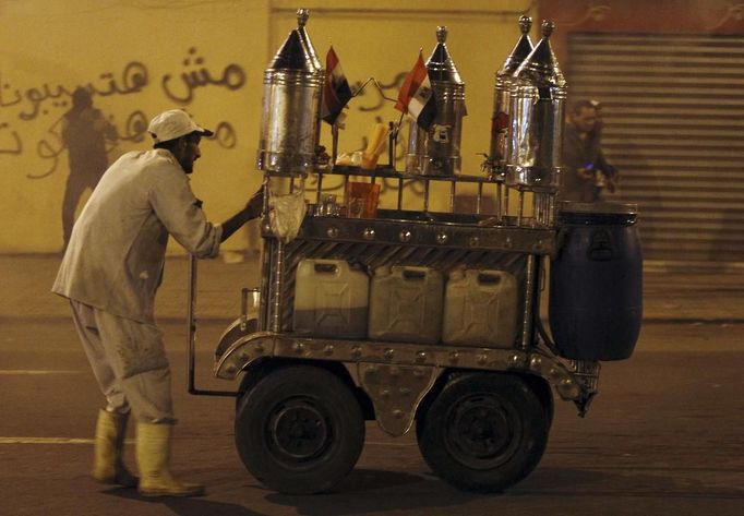 A street juice vendor and protesters, who oppose Egyptian President Mohamed Mursi, flee from teargas released by riot police during clashes in front of the presidential palace in Cairo February 11, 2013. Protesters demanding the departure of Egyptian President Mohamed Mursi clashed with police outside his palace on Monday on the second anniversary of the overthrow of veteran autocrat Hosni Mubarak. REUTERS/Amr Abdallah Dalsh (EGYPT - Tags: POLITICS CIVIL UNREST) Published: Úno. 11, 2013, 11:46 odp.