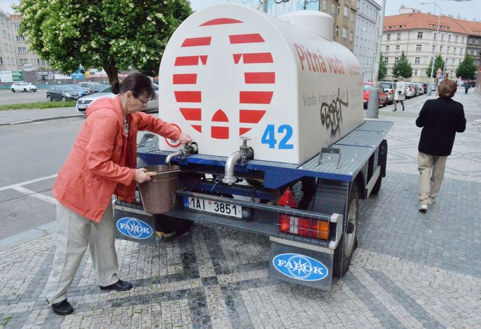 Voda v Dejvicích není pitná, lidé si musí chodit čepovat z cisteren na ulici.