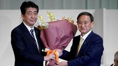 Šinzó Abe a Jošihide Suga poté, co byl Suga zvolen předsedou vládnoucí Liberálnědemokratické strany