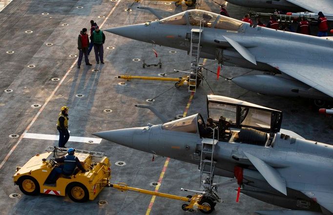 Snímek uvolnilo francouzské ministerstvo obrany. Ukazuje příslušníky francouzského námořnictva, jak dokončují servis stíhaček Dassault Rafale na vlajkové lodi Charles de Gaulle. Loď čítá posádku o 1800 lidech, nese 20 letounů a doprovází ji bojová ponorka, několik fregat a loď převážející palivo na doplnění.