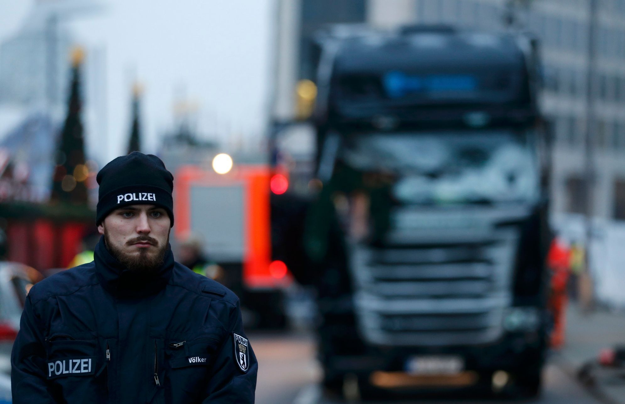 Policista před zničeným nákladním vozem, který najel do davu v Berlíně.
