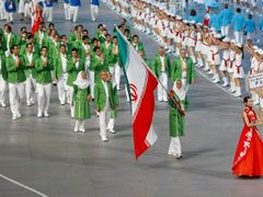 Iránská delegace pochoduje za vlajkou své země na zahájení olympijských her.